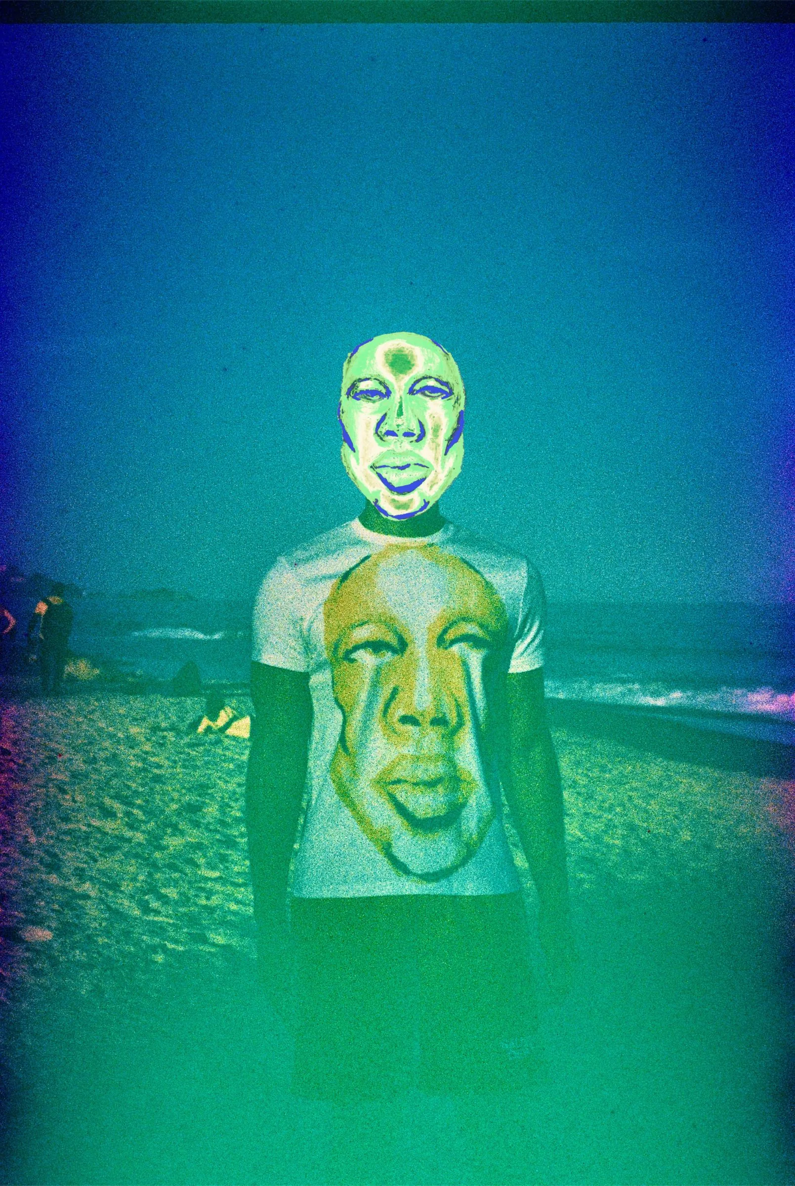 Foto do editorial: pessoa vestindo a camisa com o rosto estampado, na praia, tom esverdeado.