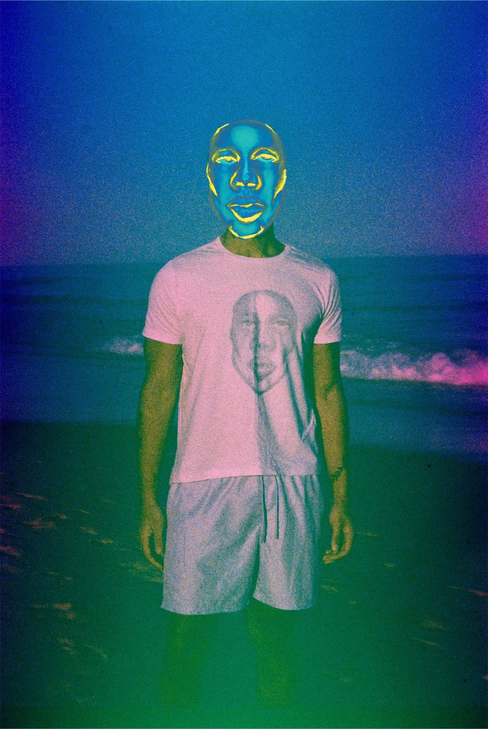 Foto do editorial: pessoa vestindo a camisa rosa com o rosto estampado, na praia.